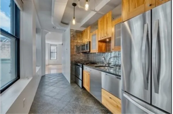 a kitchen with stainless steel appliances granite countertop a refrigerator and a stove