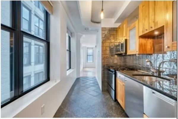 a kitchen with stainless steel appliances granite countertop a sink and a stove
