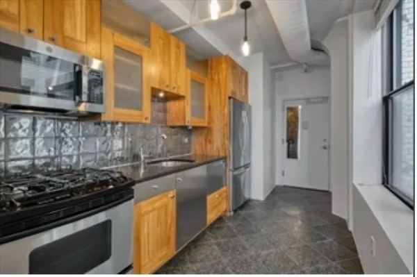 a kitchen with stainless steel appliances granite countertop a stove and a refrigerator