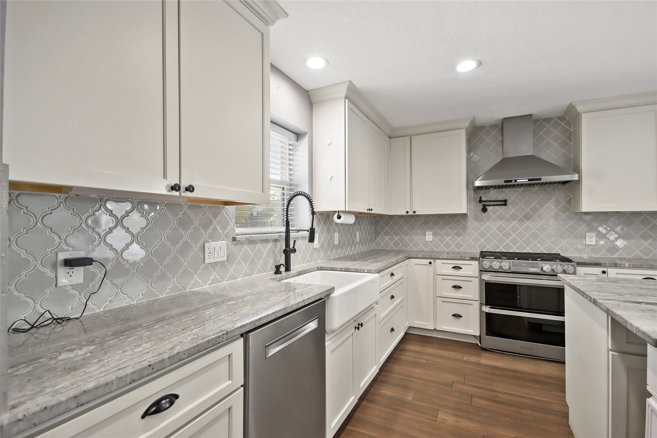 3527 Eula Morgan Road Katy, TX 77493 - Photo 3 of 23 Arabesque tile backsplash and crisp white cabinetry add a designer touch throughout the kitchen.