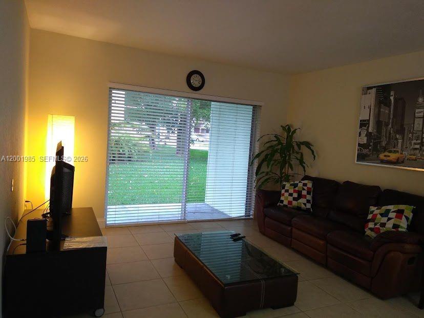 7530 Southwest 82nd Street, Unit G102 Miami, FL 33143 - Photo 3 of 9 a living room with furniture and a large window