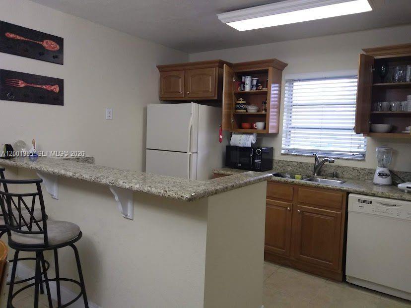 7530 Southwest 82nd Street, Unit G102 Miami, FL 33143 - Photo 4 of 9 a kitchen with stainless steel appliances a sink and a refrigerator