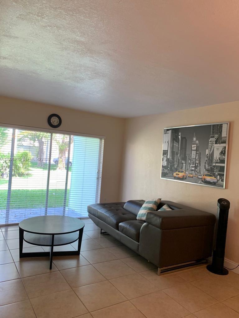 7530 Southwest 82nd Street, Unit G102 Miami, FL 33143 - Photo 5 of 9 a living room with furniture and floor to ceiling window
