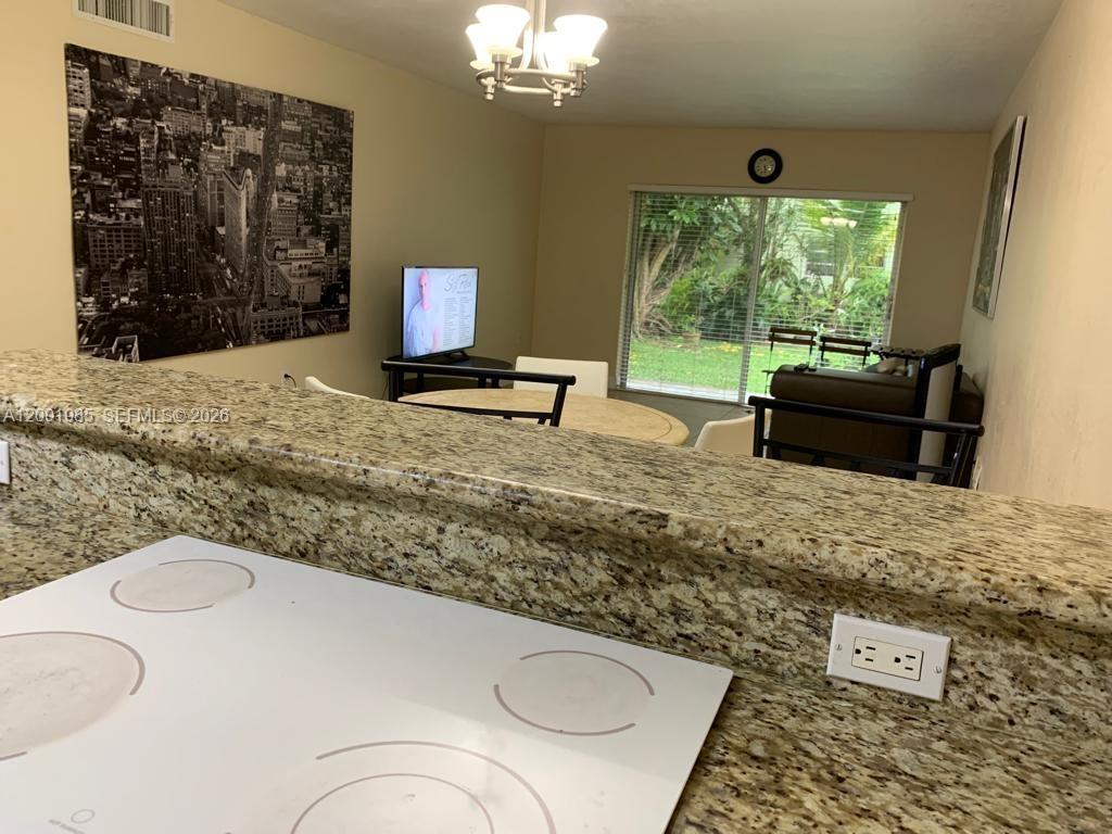7530 Southwest 82nd Street, Unit G102 Miami, FL 33143 - Photo 8 of 9 a living room with furniture and a large window