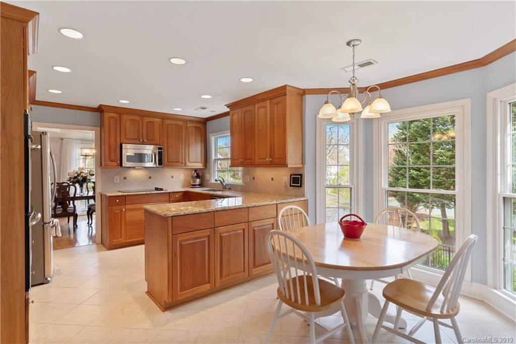 445 Cranborne Chase Fort Mill, SC 29708 - Photo 5 of 33 a kitchen with stainless steel appliances a dining table chairs and white cabinets