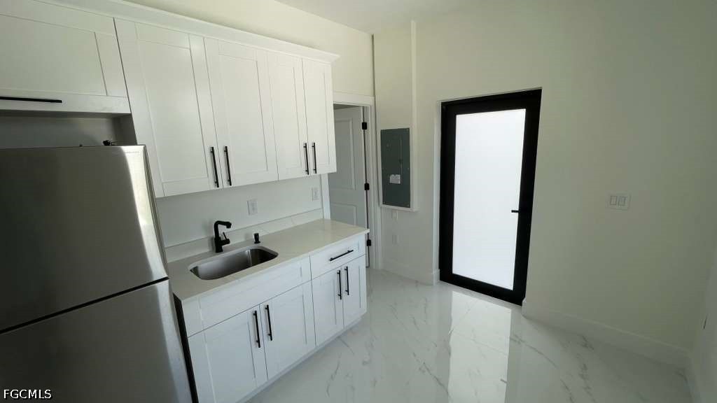 528 Raintree Street East Lehigh Acres, FL 33974 - Photo 4 of 10 a kitchen with white cabinets and refrigerator