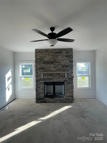 a living room with a fireplace and a ceiling fan