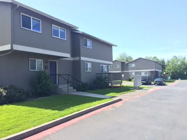 a view of a house with a yard and a large tree