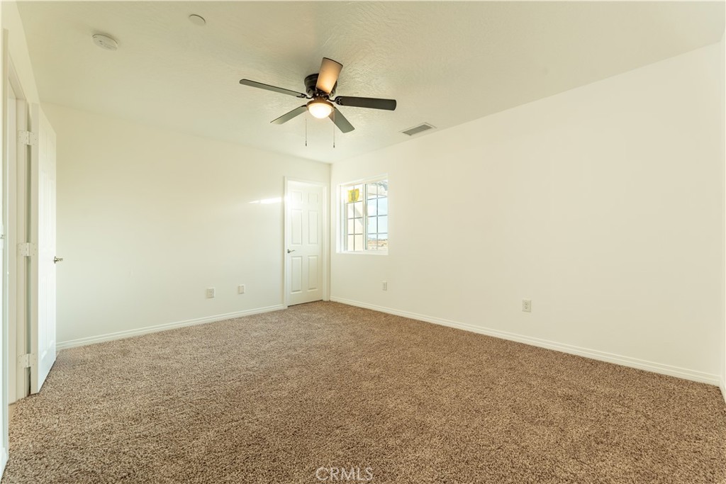 16925 Nanticoke Road Apple Valley, CA 92307 - Photo 62 of 87 an empty room with a window and a fan