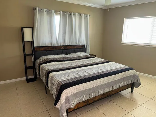 a bed sitting in a bedroom next to a window