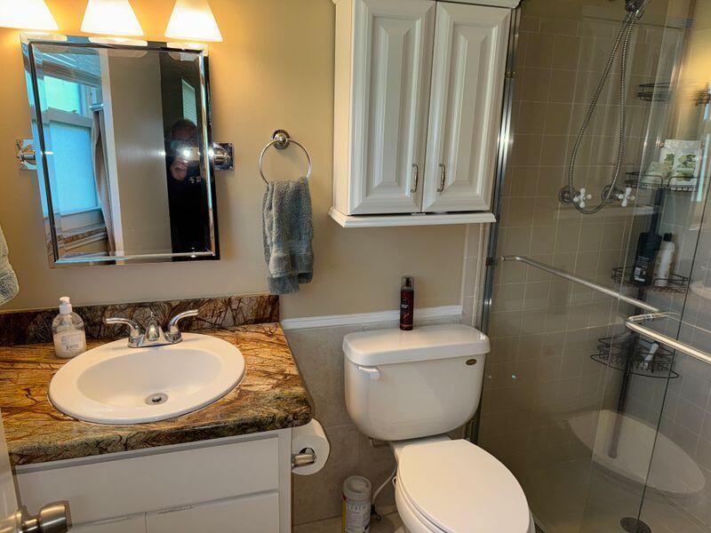 5501 Northwest 2nd Avenue, Unit 310 Boca Raton, FL 33487 - Photo 13 of 23 a bathroom with a toilet sink and mirror