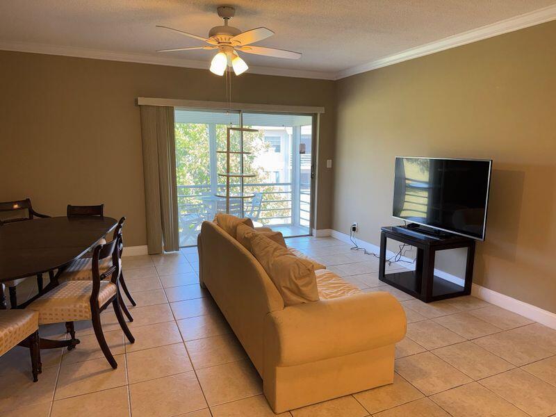 5501 Northwest 2nd Avenue, Unit 310 Boca Raton, FL 33487 - Photo 8 of 23 a living room with furniture and a flat screen tv
