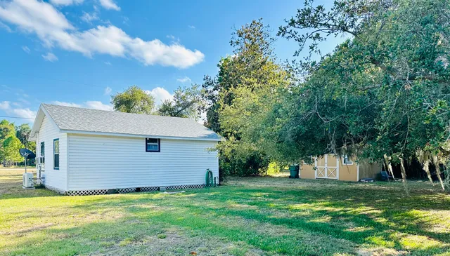 a white house that has a tree in front of it