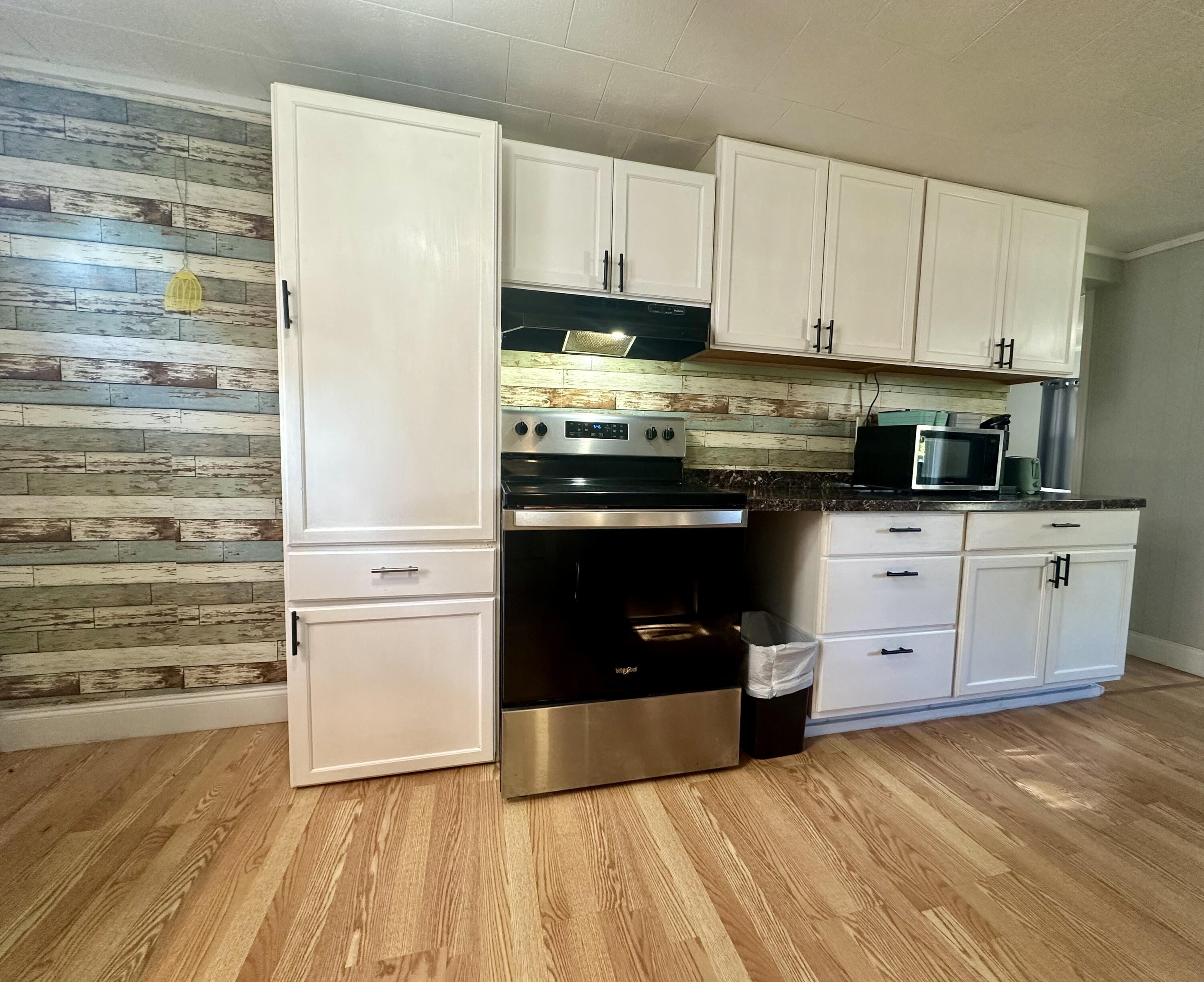 1104 Southwest 11th Street Okeechobee, FL 34974 - Photo 22 of 59 a kitchen with stainless steel appliances a stove and white cabinets