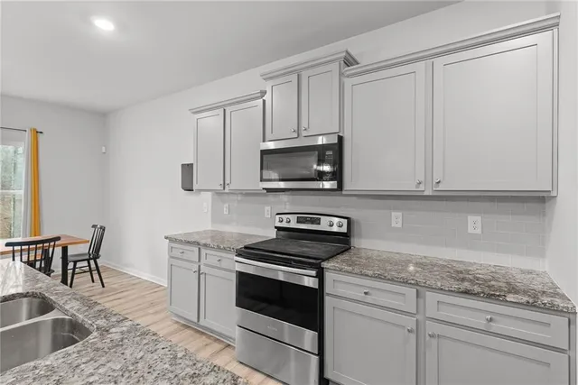 a kitchen with granite countertop white cabinets and white appliances