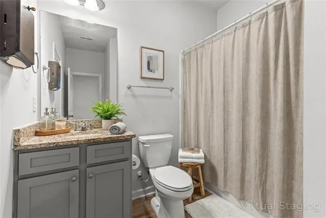 a bathroom with a granite countertop sink and a toilet