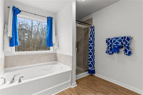 a bathroom with a tub a double vanity sink and a large mirror