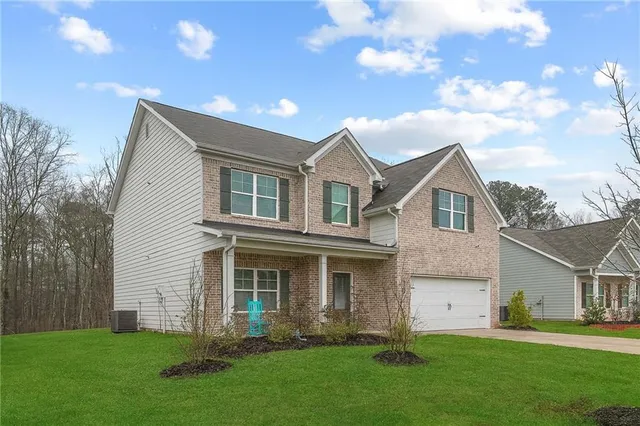 a front view of a house with a garden and yard