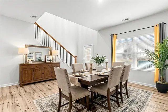 a dining room with wooden floor and large windows