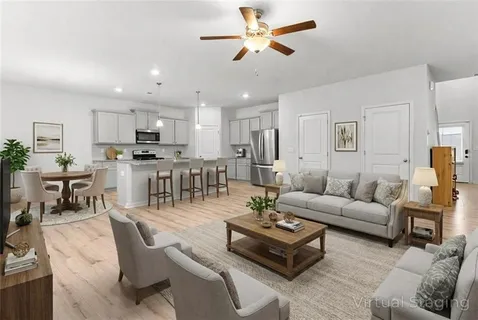 a living room with furniture kitchen view and a chandelier