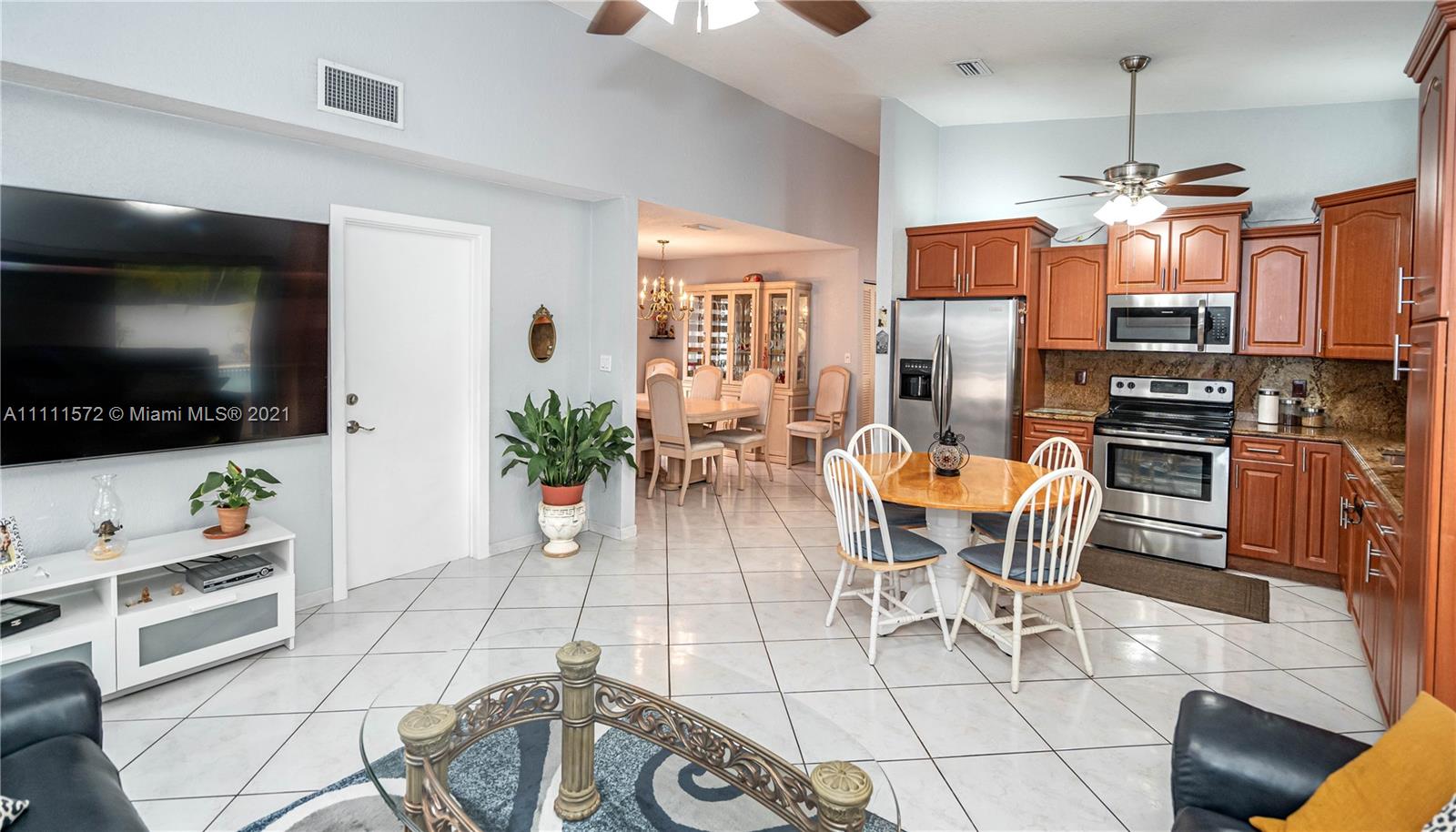 14695 Southwest 45th Street Miami, FL 33175 - Photo 20 of 33 a view of a dining room with furniture a kitchen and chandelier