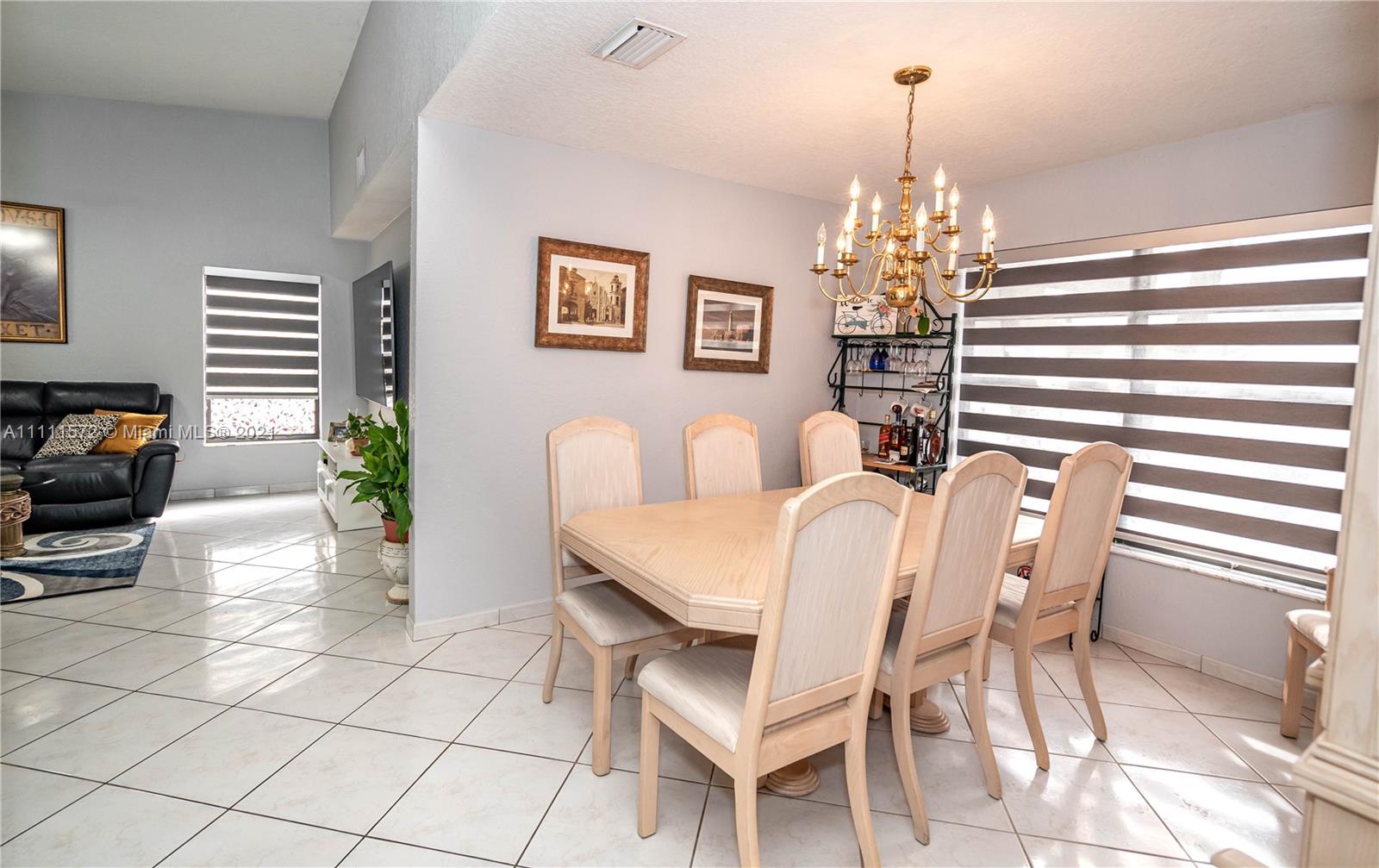 14695 Southwest 45th Street Miami, FL 33175 - Photo 22 of 33 a dining room with furniture a chandelier and wooden floor