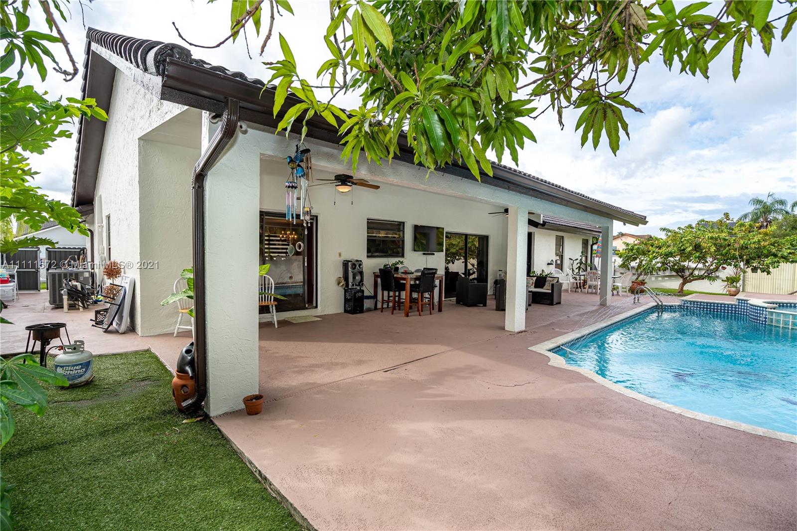 14695 Southwest 45th Street Miami, FL 33175 - Photo 7 of 33 a view of a chair and tables in the patio next to a yard