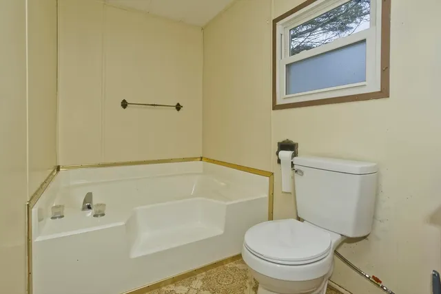 a white toilet sitting next to a bath tub