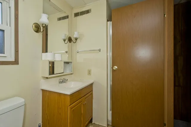 a bathroom with a sink and mirror with toilet