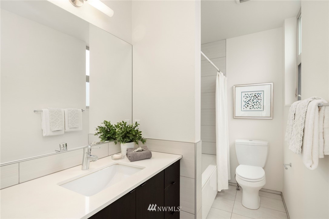1829 24th Avenue, Unit A Seattle, WA 98122 - Photo 15 of 25 a bathroom with a sink a toilet and a large mirror