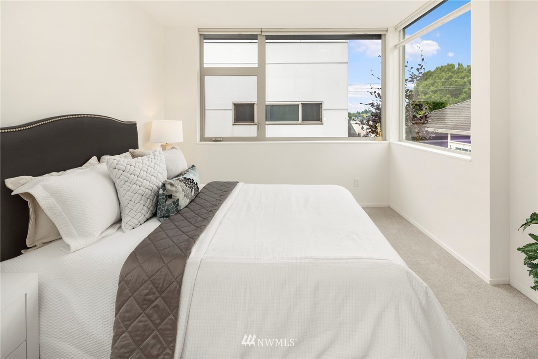1829 24th Avenue, Unit A Seattle, WA 98122 - Photo 17 of 25 a bedroom with a large bed and a large window