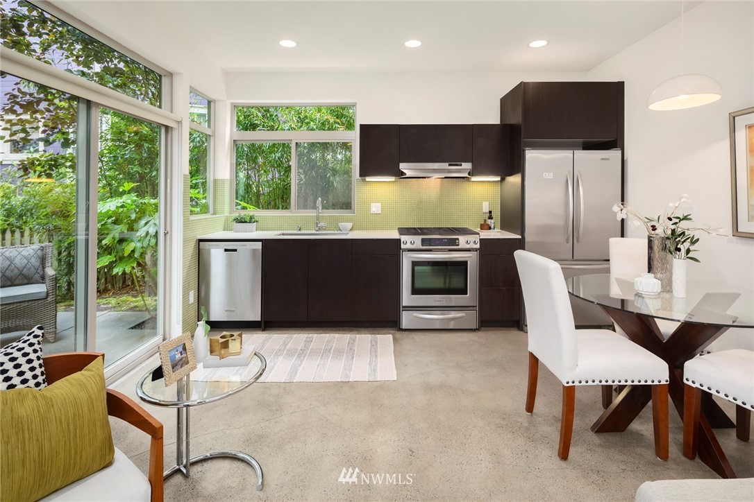 1829 24th Avenue, Unit A Seattle, WA 98122 - Photo 4 of 25 a kitchen with stainless steel appliances granite countertop a stove and a view of living room
