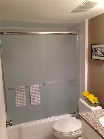 245 Kelton Street, Unit 11 Boston, MA 02134 - Photo 6 of 12 a bathroom with a granite countertop bathtub shower sink vanity and toilet