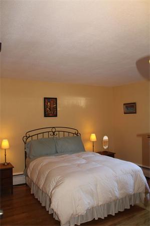 245 Kelton Street, Unit 11 Boston, MA 02134 - Photo 8 of 12 a bedroom with a bed and wooden floor