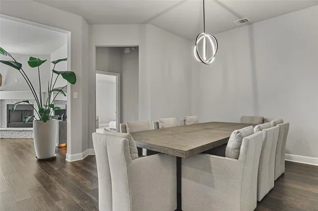 a dining room with table chairs and wooden floor