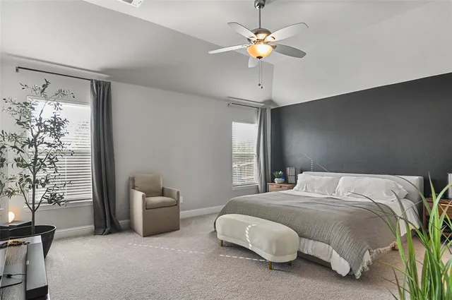 a bedroom with a bed chandelier fan and a window