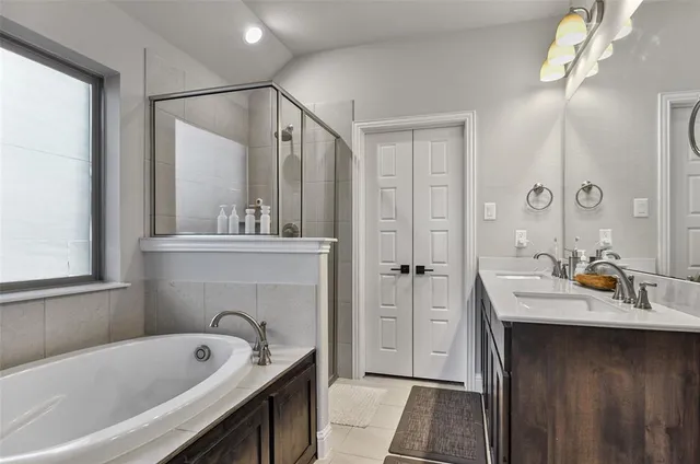 a bathroom with a tub a sink and mirror