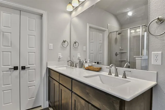 a en suite bathroom with a sink double vanity and a mirror