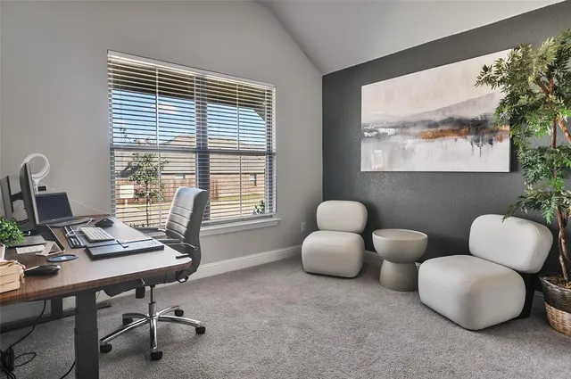 a view of a workspace with furniture and a window