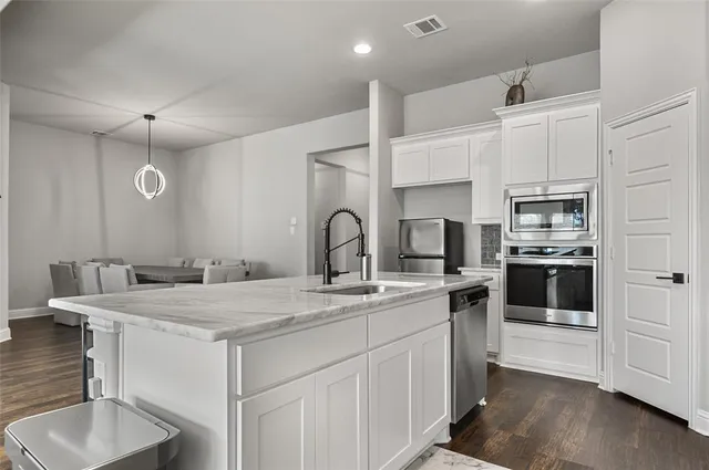 a kitchen with a sink a stove and cabinets