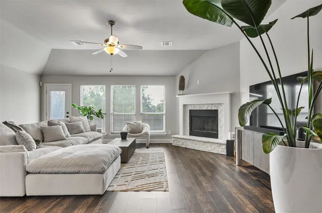 a living room with furniture a fireplace and a chandelier