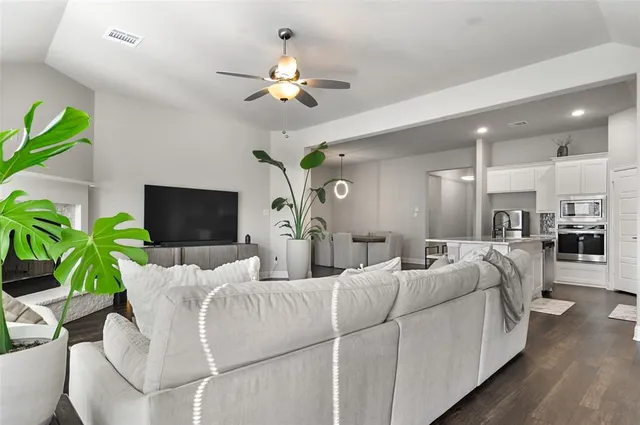 a living room with furniture a chandelier and a flat screen tv