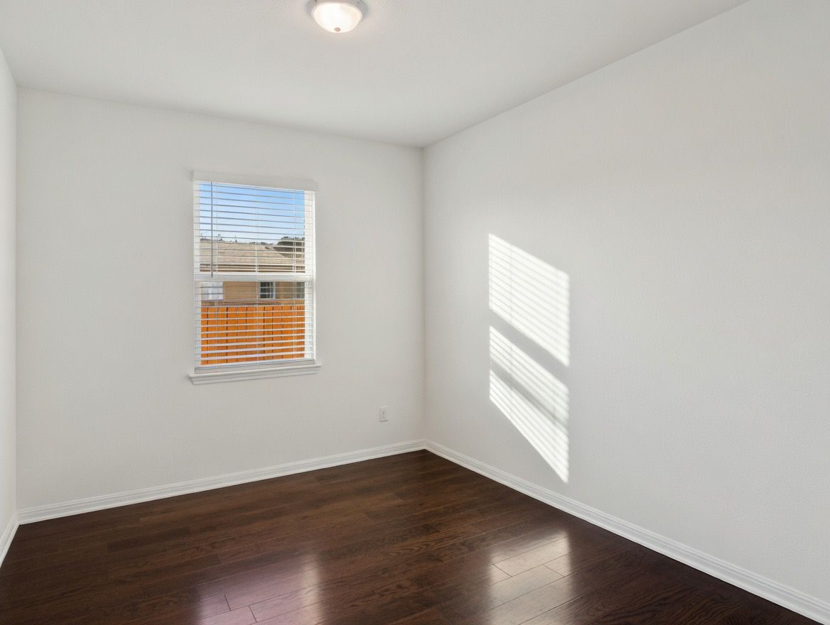4002 Wynn Road Hutto, TX 78634 - Photo 15 of 29 Empty room featuring dark wood finished floors and baseboards