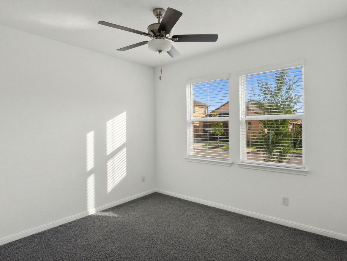 4002 Wynn Road Hutto, TX 78634 - Photo 16 of 29 Empty room with ceiling fan and dark carpet