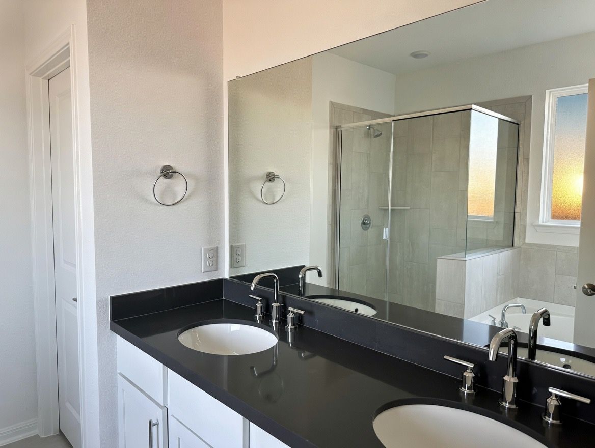 4002 Wynn Road Hutto, TX 78634 - Photo 20 of 29 Bathroom with double vanity, a stall shower, and a bath