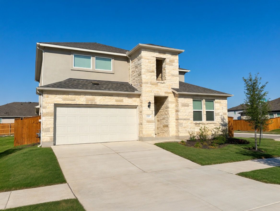 4002 Wynn Road Hutto, TX 78634 - Photo 3 of 29 View of front of home with stone siding, a shingled roof, driveway, and a garage