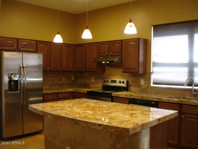 a kitchen with a sink a refrigerator and cabinets