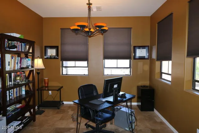 a view of a workspace with furniture and a window