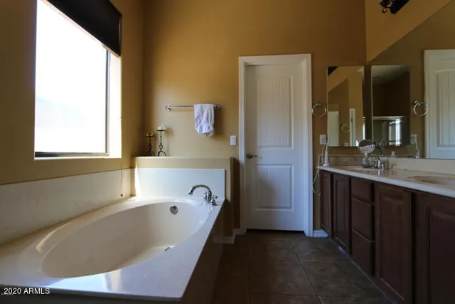 a bathroom with a tub sink and mirror
