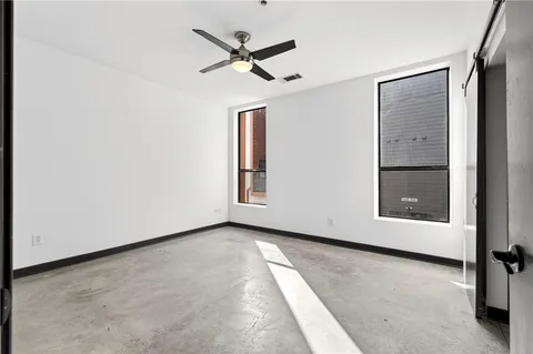 an empty room with closet and windows